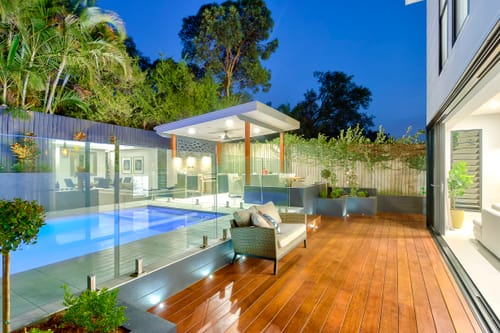 Backyard swimming pool enclosed by a compliant glass pool safety barrier in Queensland
